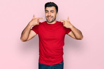 Cómo combinar una playera roja para un outfit casual de hombre con jeans y tenis