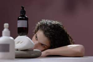 Mujer con cabello rizado y shampoo sin sulfato